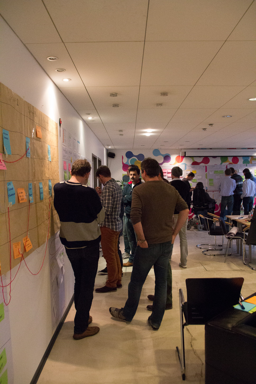 Workshop participants working at a wall of sticky notes